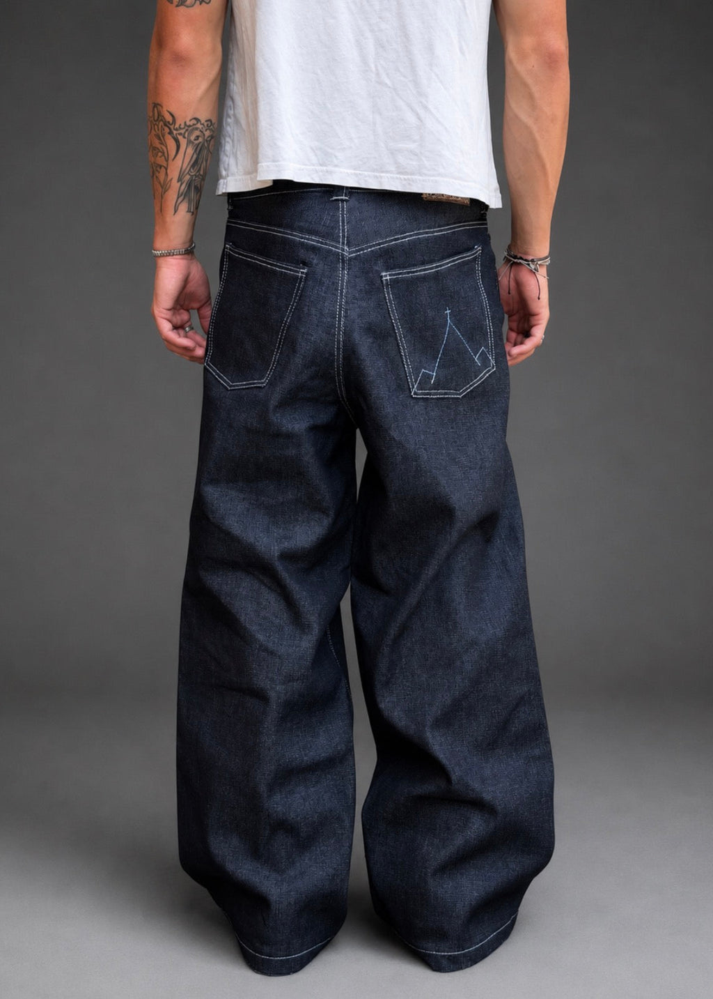 Divine 144 baggy raw indigo denim jeans with wide straight-leg fit and signature mountain embroidery on back pocket