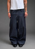 Divine 144 baggy raw indigo denim jeans with a wide straight-leg fit and contrast stitching on a model