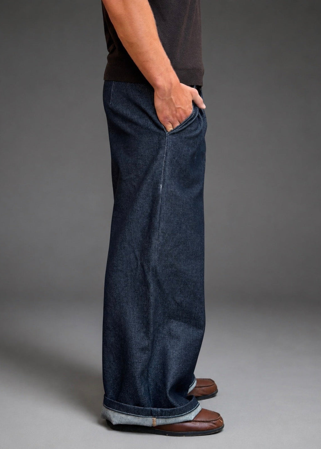 Divine 144 dark indigo raw denim trousers with a wide straight-leg fit and double pleats, side view on a model.