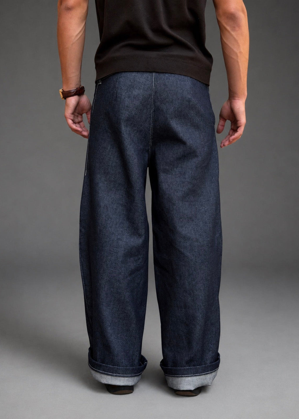 Divine 144 raw indigo denim trousers with a wide straight-leg fit and cuffed hems, viewed from the back.